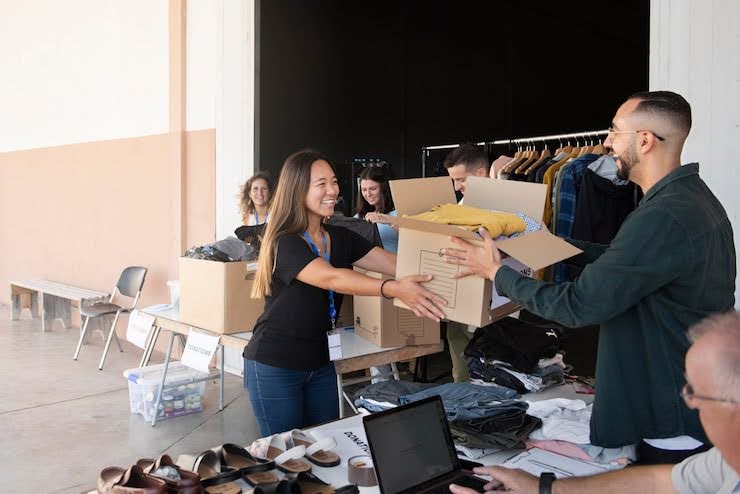 Retail team handing over boxes during a busy operations period